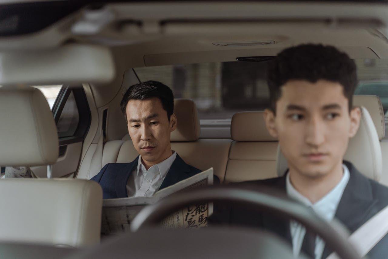 2 Men in White Suit Sitting Inside Car